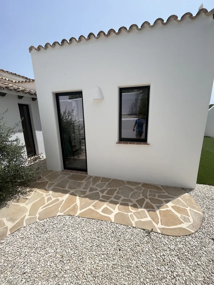 Vivienda reformada y ampliada en Moraira, con fachada blanca y carpintería nueva